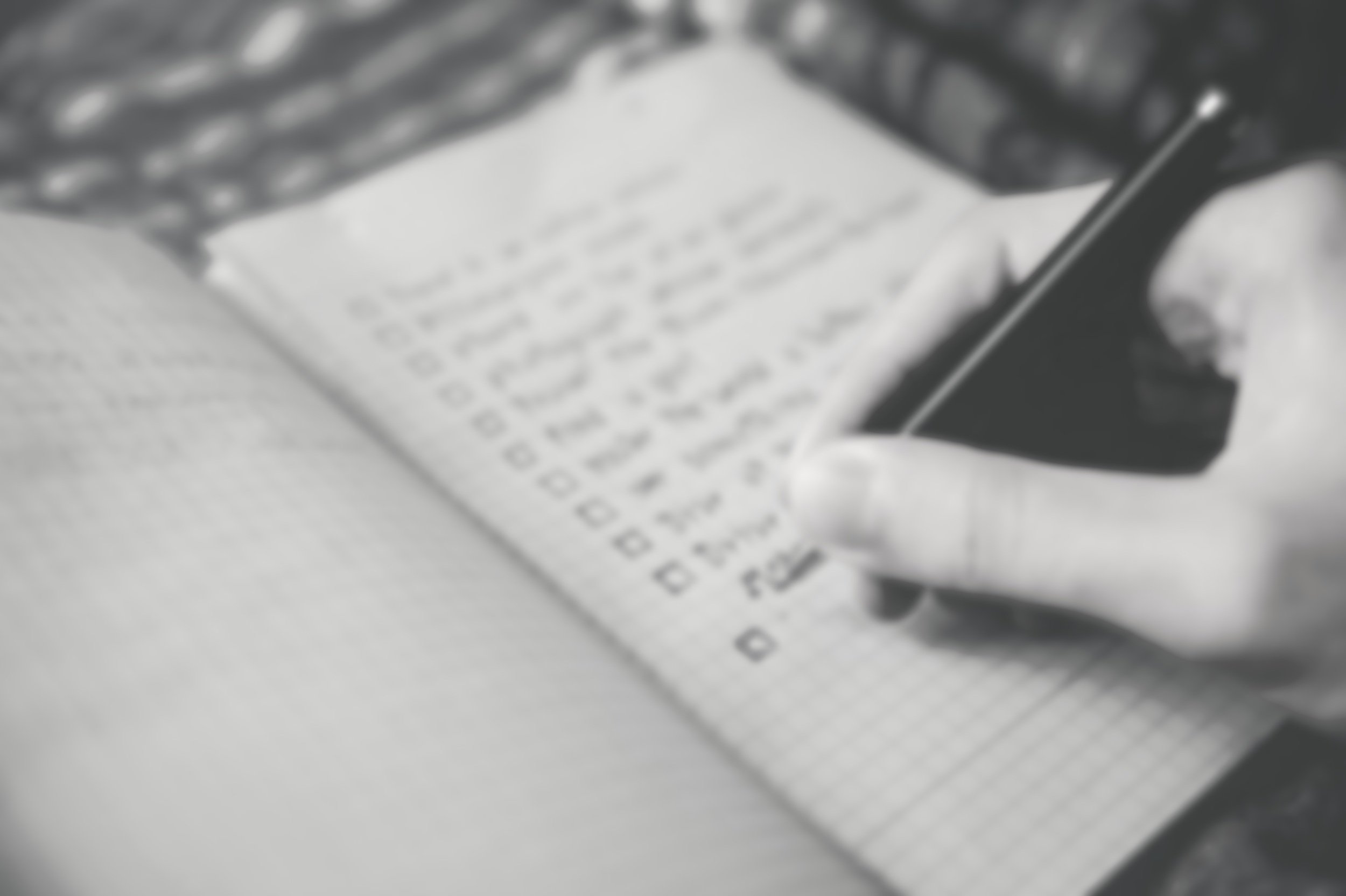 Close-up of a hand checking off items on a written checklist